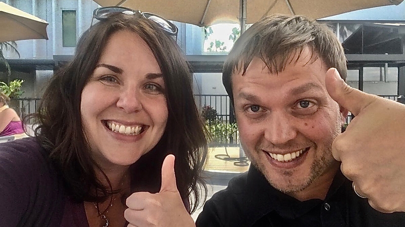 Authors Jodie Black and Eric Moore smiling and giving thumbs up gestures.