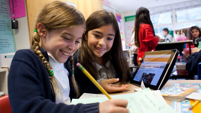 Pair of students doing school work with a tablet