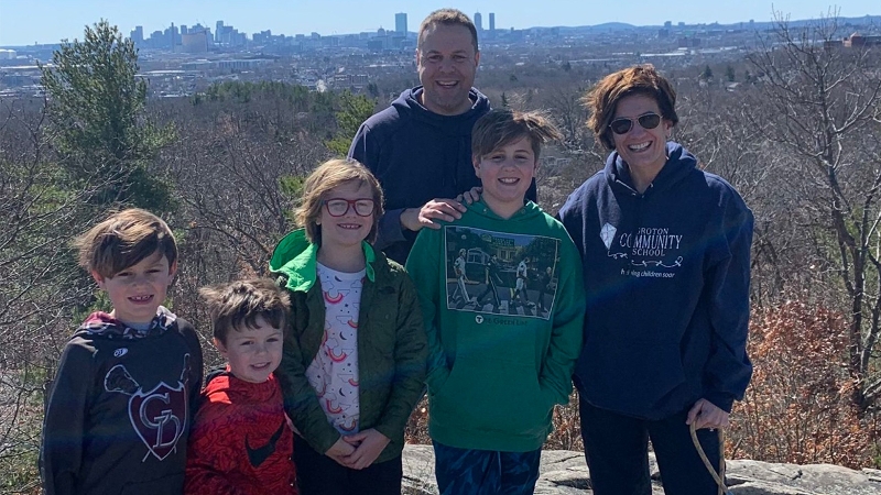 Author Katie Novak with her husband and four children standing on a hill with a city in the background.
