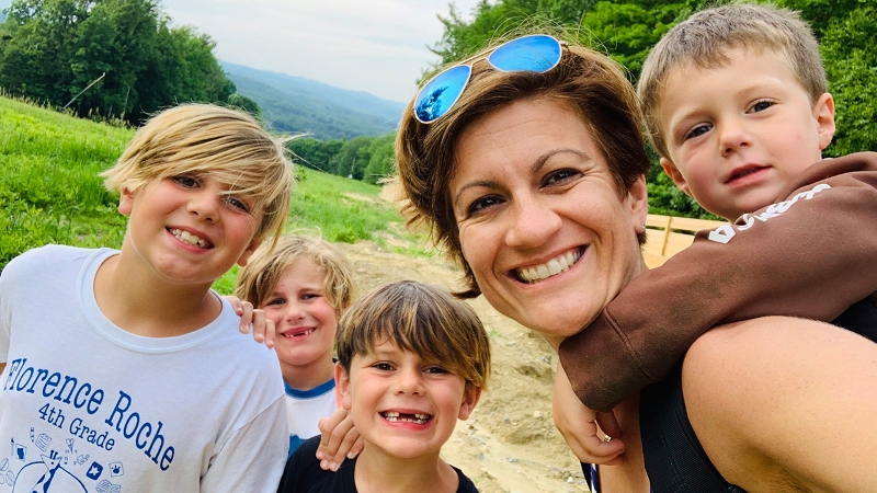 Photo of author Katie Novak with her four children, smiling and posing while on a hike.